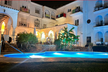 Outdoor swimming pool, lit up at night, at the Residencia Miami hotel in La Carihuela, Torremolinos.